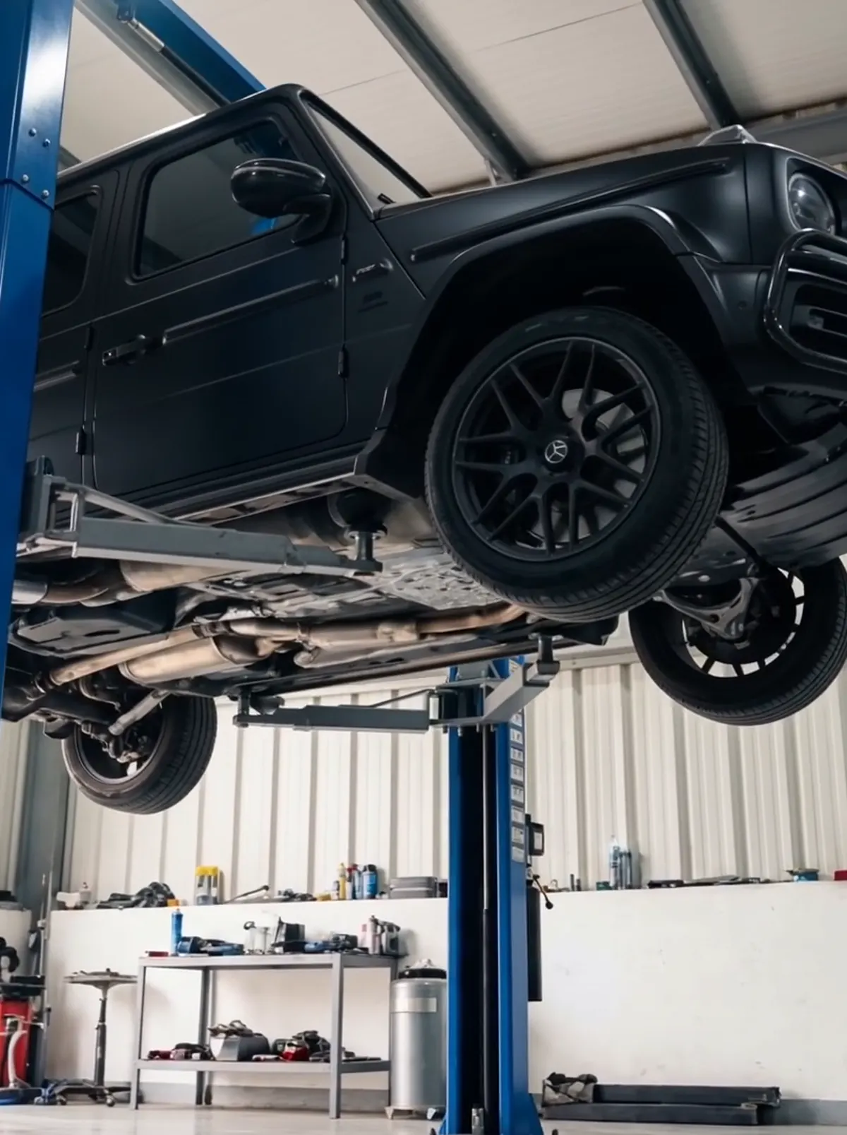 An SUV raised on a two-post lift